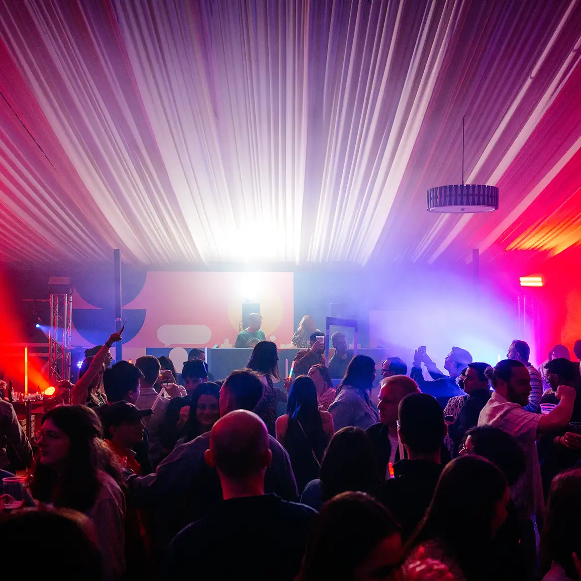 Corporate party crowd in front of stage with lighting