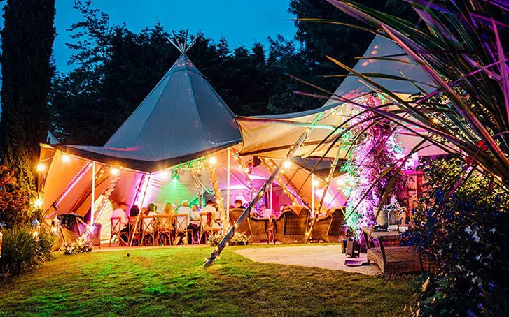 tipi tents with decorative coloured lighting at an immersive party