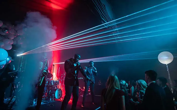 A band on stage at an event in a marquee