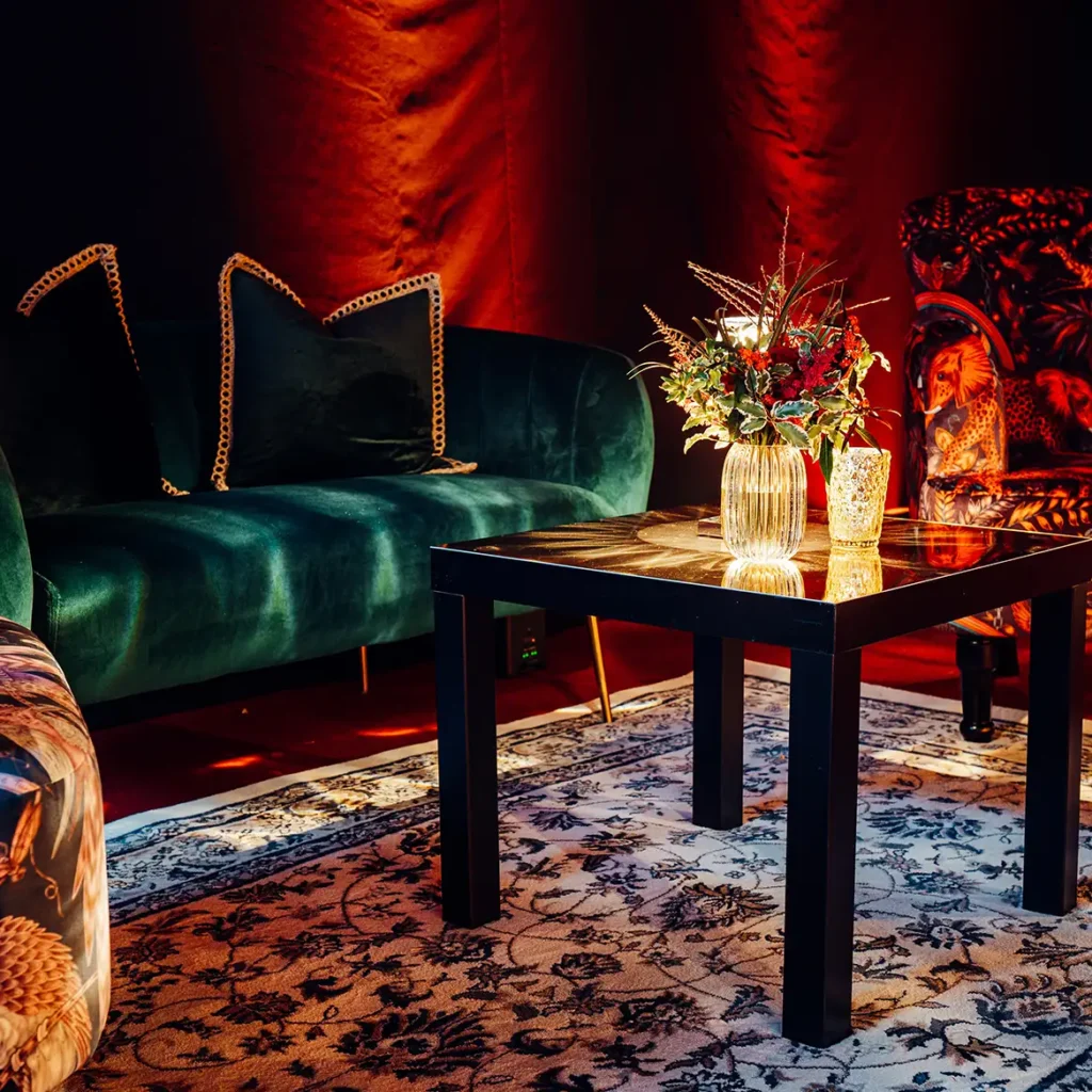 Green sofas and low tables with floral centrepieces