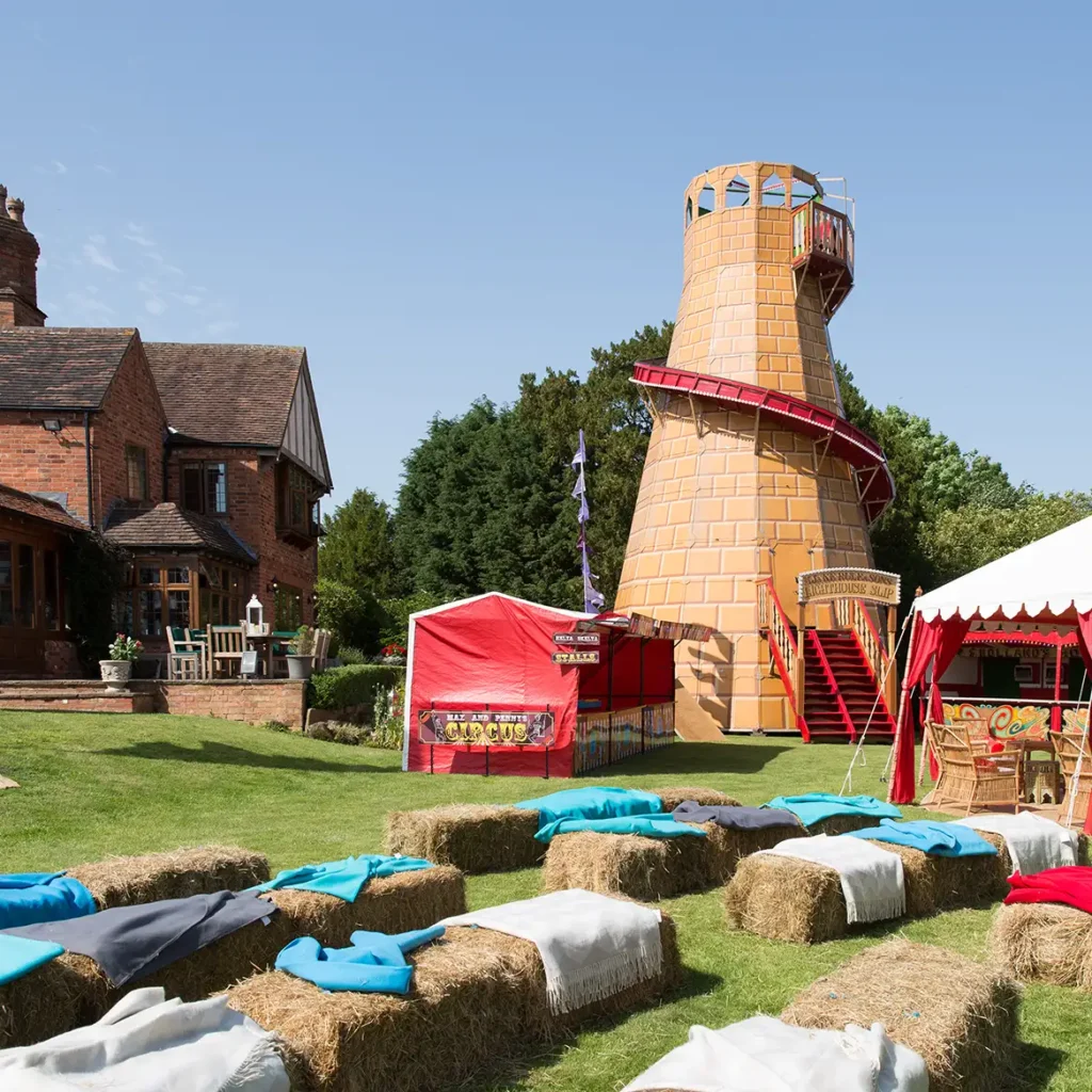 Helter skelta and hay bales in lush garden