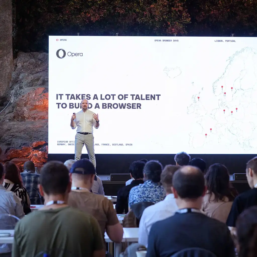 Large video wall with man presenting on stage