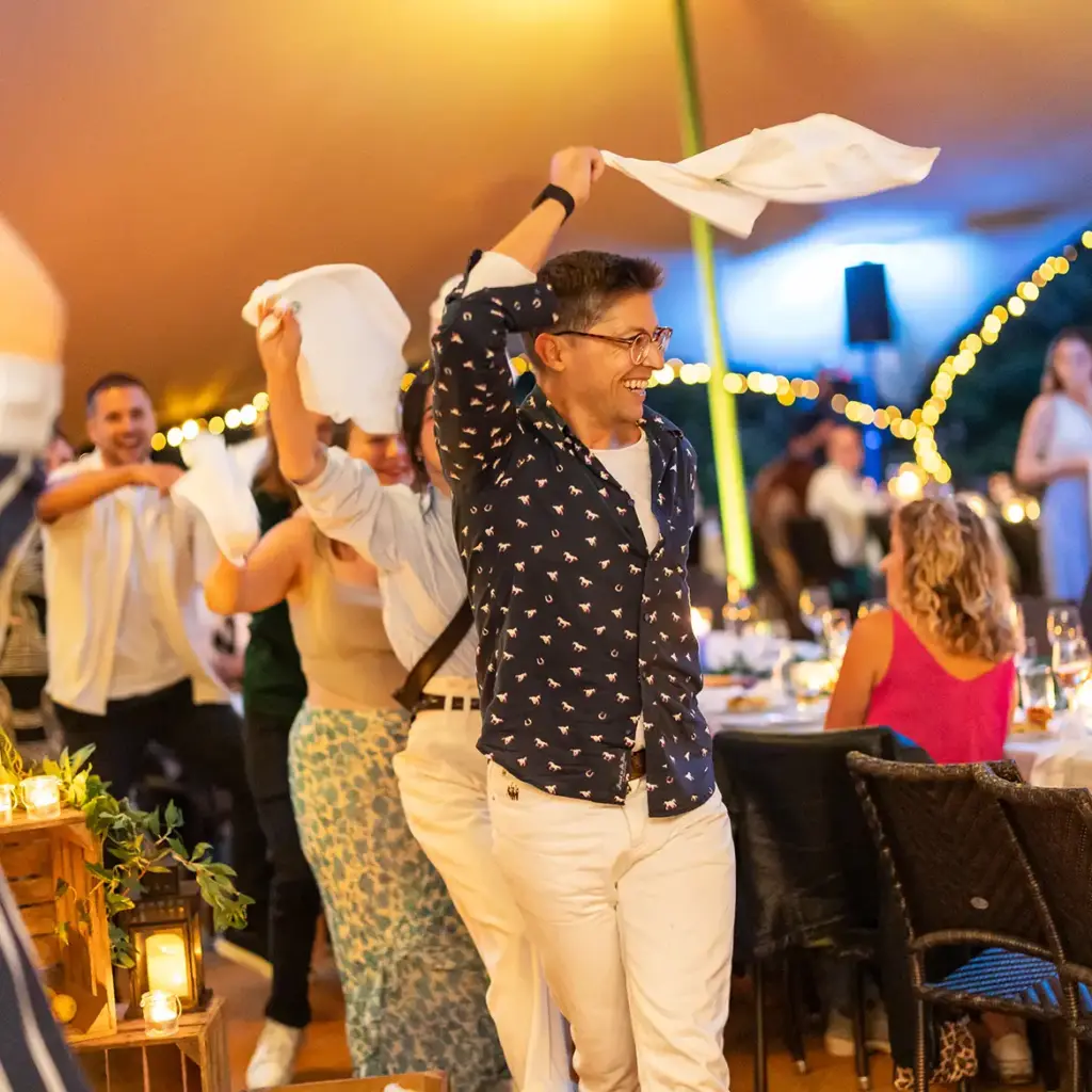 People waving napkins in good spirits doing the conga line